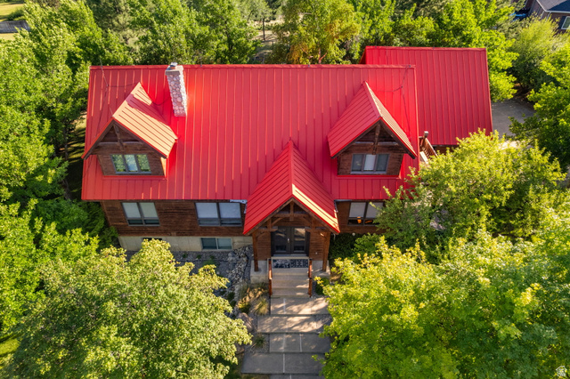 435 Canyon Road Millville, UT 84326 - Photo 113 of 113 Wood-clad exterior with a prominent red metal roof, dormer windows, and a stone chimney