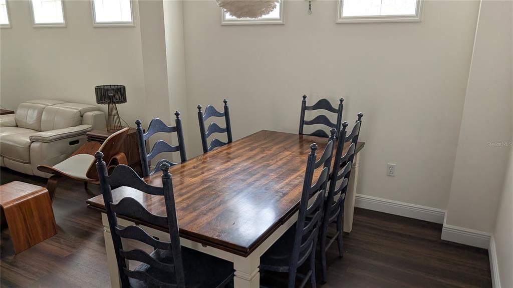 6264 Wingspan Way Bradenton, FL 34203 - Photo 13 of 27 a view of a dining room with furniture and wooden floor