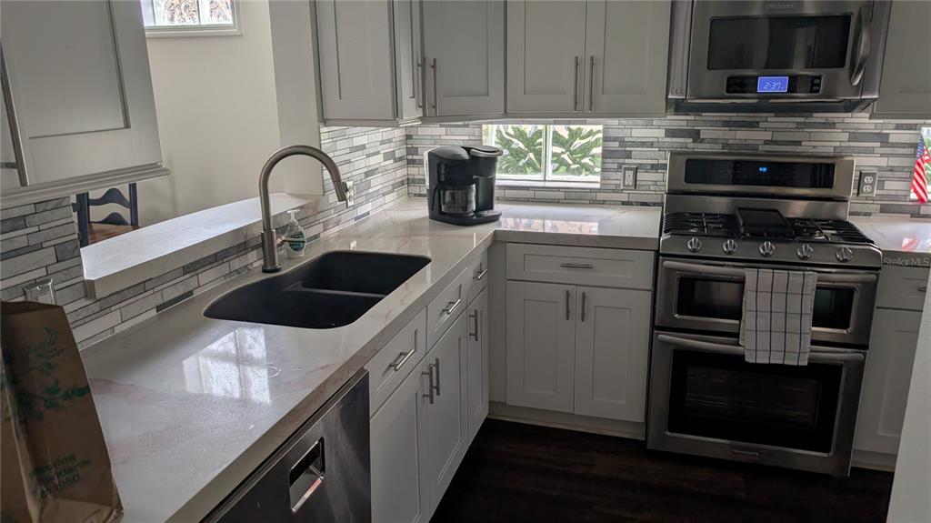 6264 Wingspan Way Bradenton, FL 34203 - Photo 15 of 27 a kitchen with a sink and a stove top oven