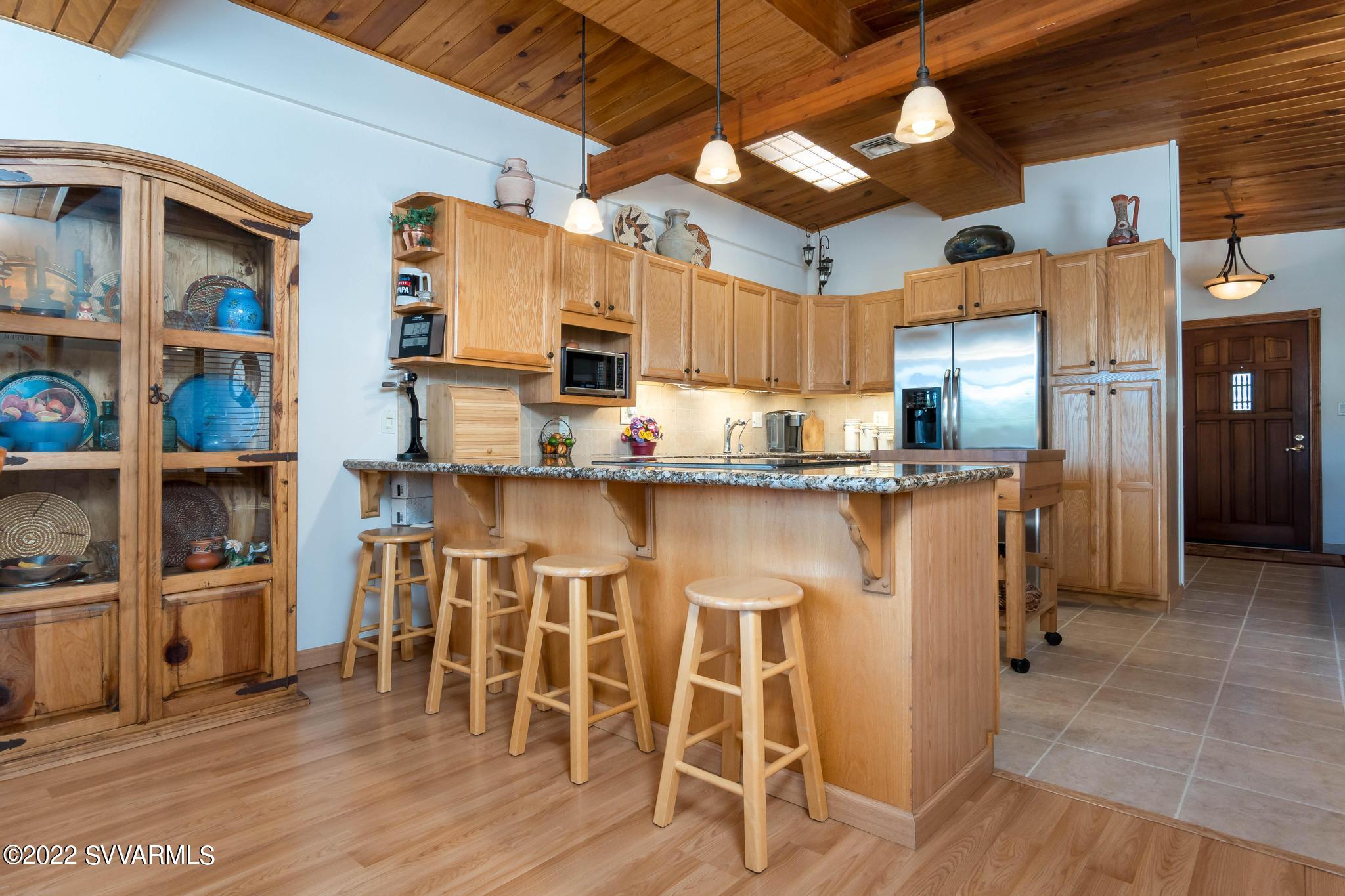 3685 East Rimrock Drive Rimrock, AZ 86335 - Photo 15 of 47 a kitchen with stainless steel appliances granite countertop a table chairs in it and wooden floors