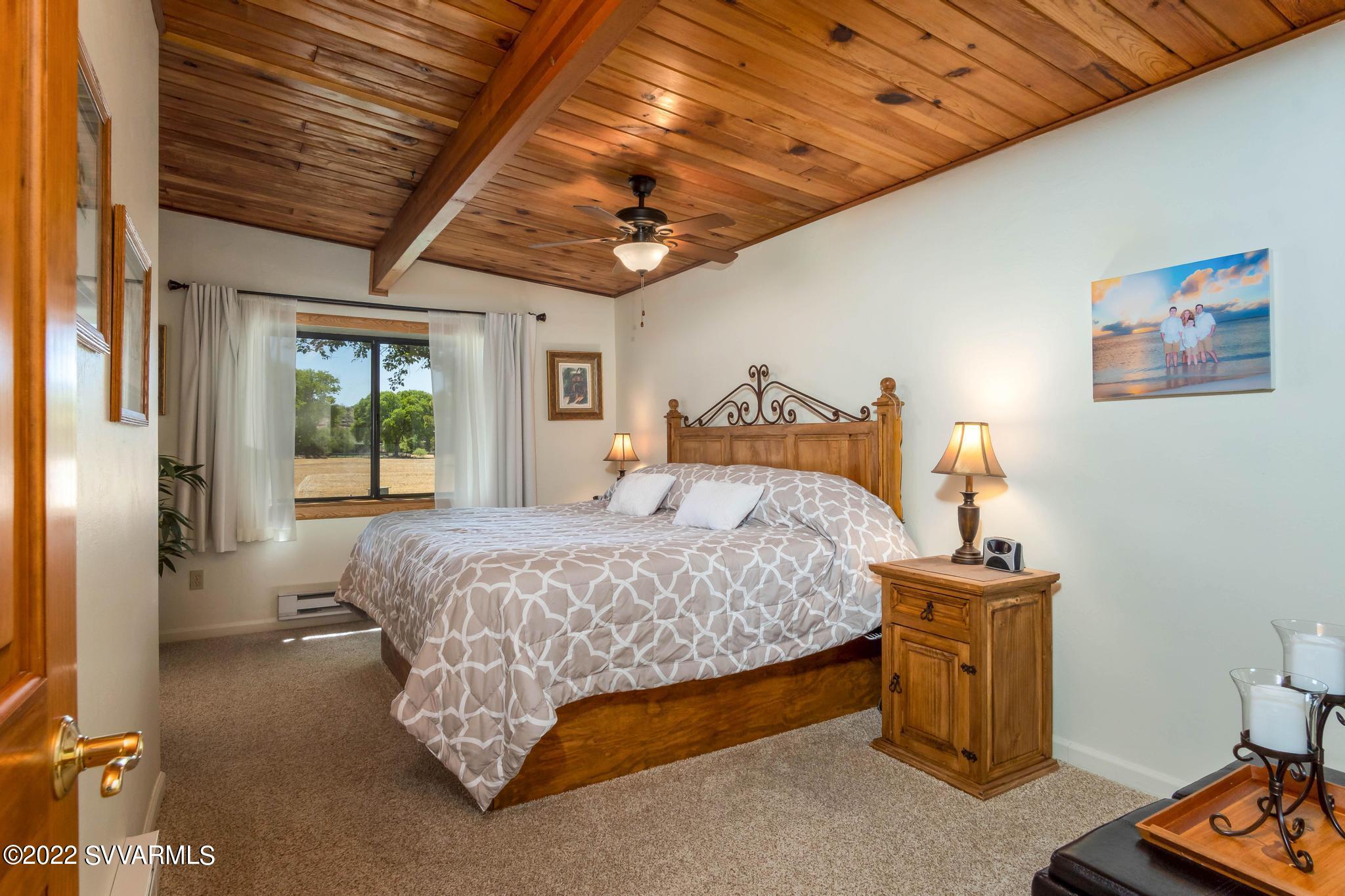 3685 East Rimrock Drive Rimrock, AZ 86335 - Photo 18 of 47 a bedroom with a bed and a chandelier