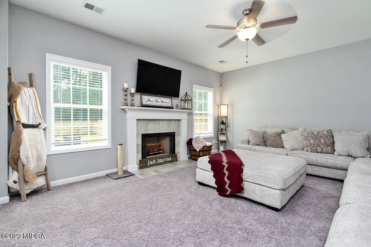 4227 Cornwall Drive Forsyth, GA 31029 - Photo 12 of 27 a living room with furniture a flat screen tv and a fireplace
