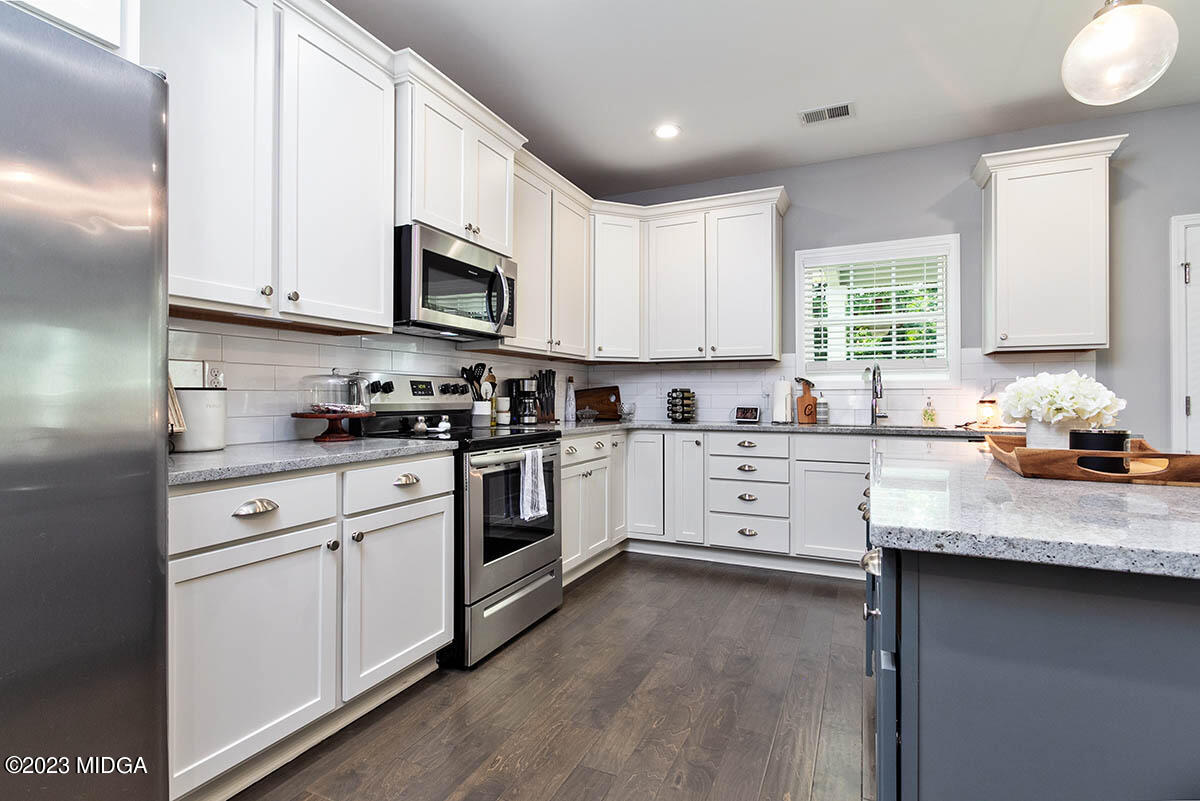 4227 Cornwall Drive Forsyth, GA 31029 - Photo 8 of 27 a kitchen with granite countertop white cabinets and white appliances