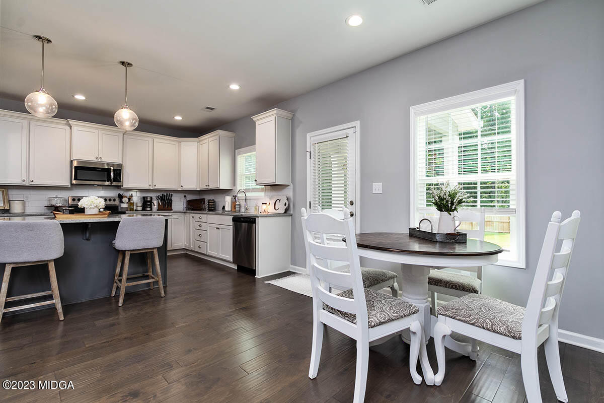 4227 Cornwall Drive Forsyth, GA 31029 - Photo 10 of 27 a kitchen with stainless steel appliances kitchen island granite countertop a dining table chairs and sink