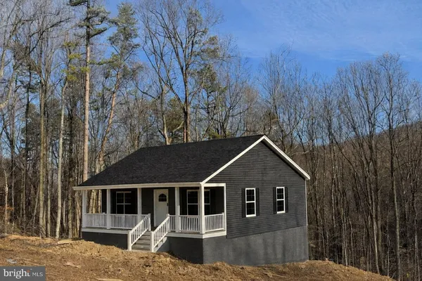 a front view of a house with yard and trees