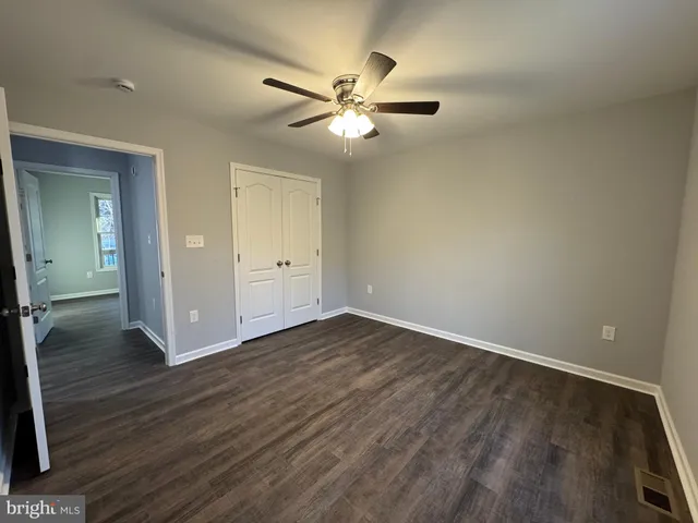 a view of an empty room with wooden floor