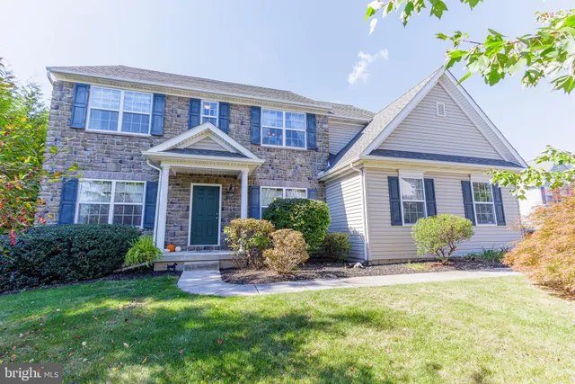 a front view of a house with yard and green space
