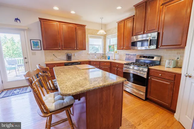 a kitchen with stainless steel appliances granite countertop wooden cabinets a stove top oven a sink and dishwasher