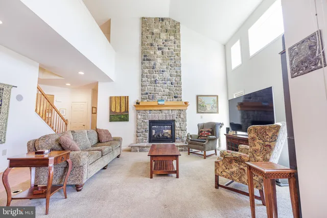 a living room with furniture large window and a fireplace