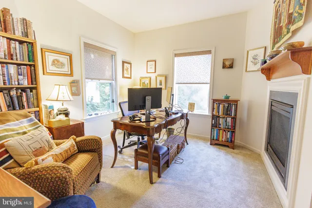 a living room with furniture a bookshelf and a window