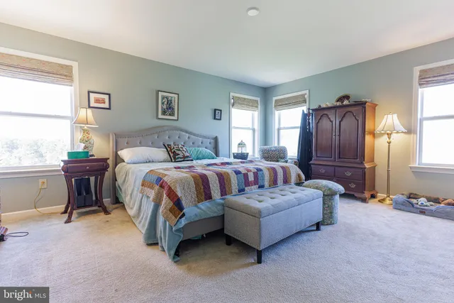 a spacious bedroom with a bed and wooden floor