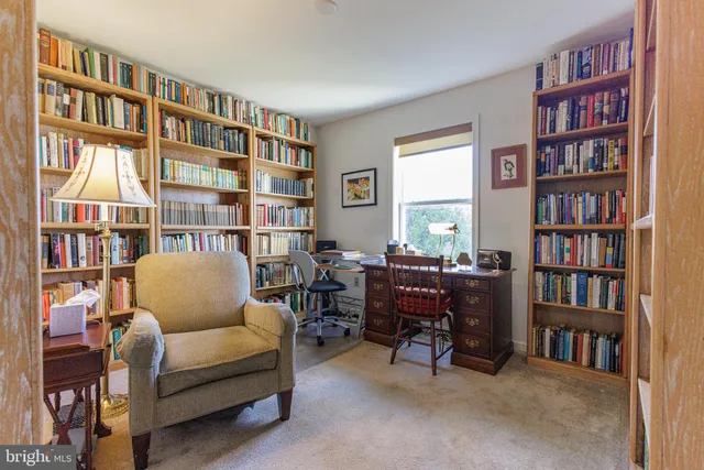 a living room with furniture and a book shelf