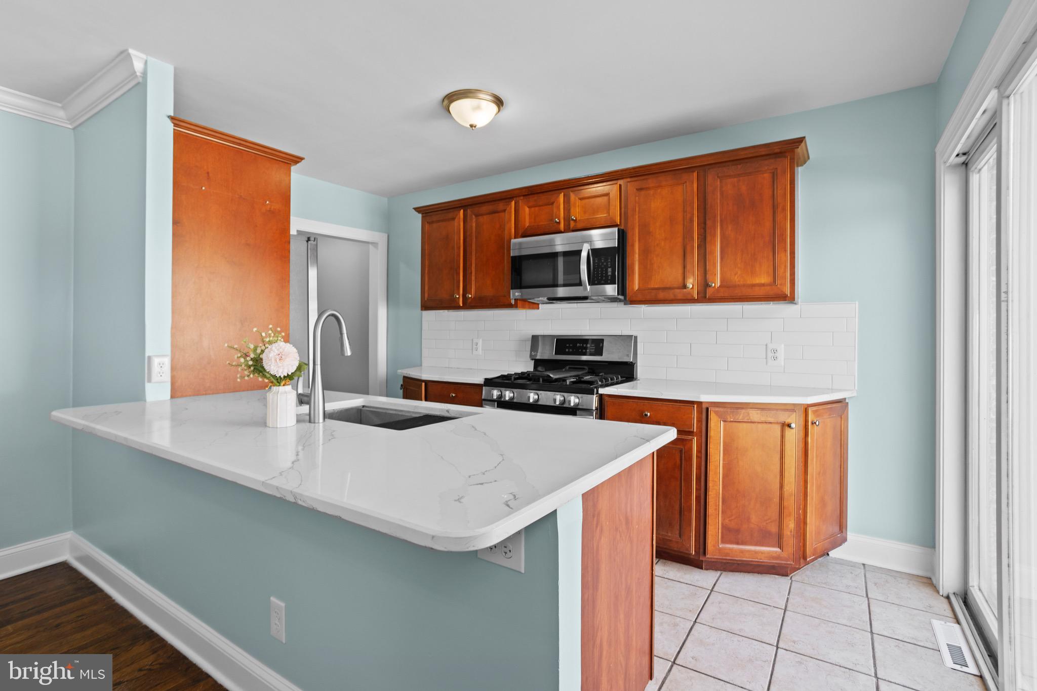 1309 Grace Road Swarthmore, PA 19081 - Photo 9 of 33 a kitchen with stainless steel appliances a stove a sink and a microwave
