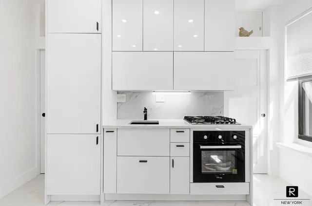 a kitchen with white cabinets and white stove