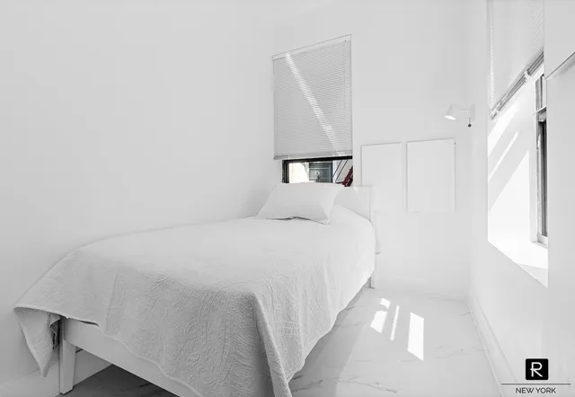 a large white bed in a white room
