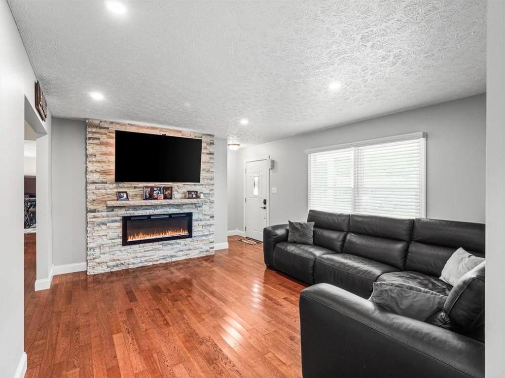 27 Spring Valley Street Slovan, PA 15078 - Photo 6 of 30 a living room with furniture a flat screen tv and a fireplace