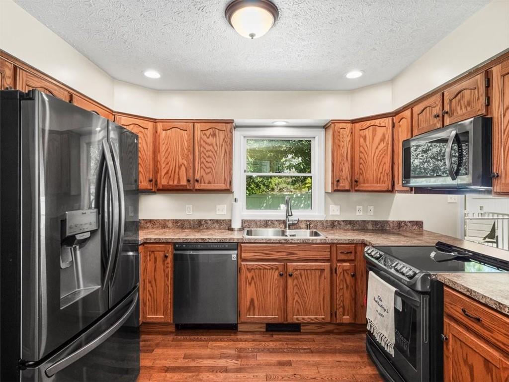 27 Spring Valley Street Slovan, PA 15078 - Photo 10 of 30 a kitchen with stainless steel appliances granite countertop a stove a refrigerator a sink and dishwasher