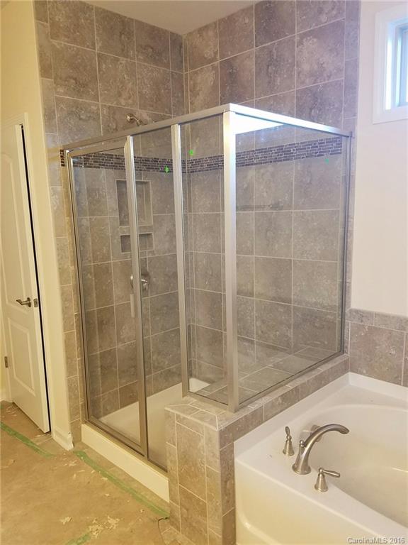 7010 Fallondale Road, Unit MB528 Waxhaw, NC 28173 - Photo 11 of 16 a bathroom with a bathtub and shower