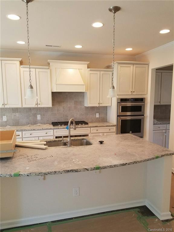 7010 Fallondale Road, Unit MB528 Waxhaw, NC 28173 - Photo 3 of 16 a kitchen with kitchen island granite countertop a stove a sink and a granite counter top