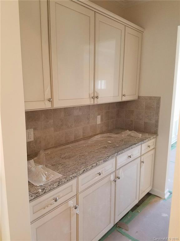 7010 Fallondale Road, Unit MB528 Waxhaw, NC 28173 - Photo 5 of 16 a kitchen with granite countertop white cabinets and sink