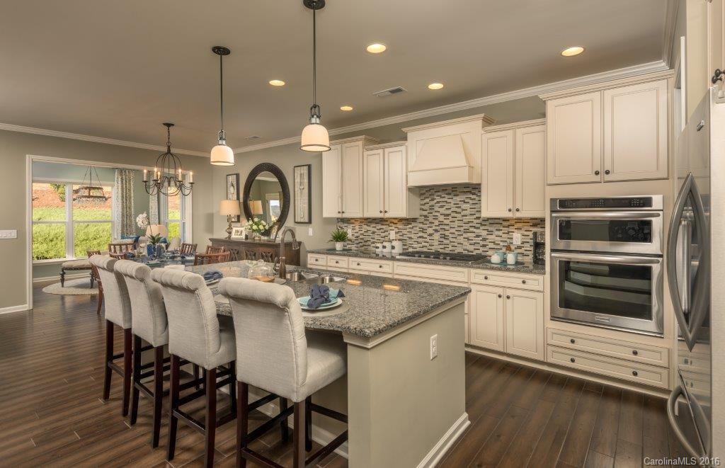 7010 Fallondale Road, Unit MB528 Waxhaw, NC 28173 - Photo 6 of 16 a kitchen with stainless steel appliances granite countertop a kitchen island hardwood floor sink and stove