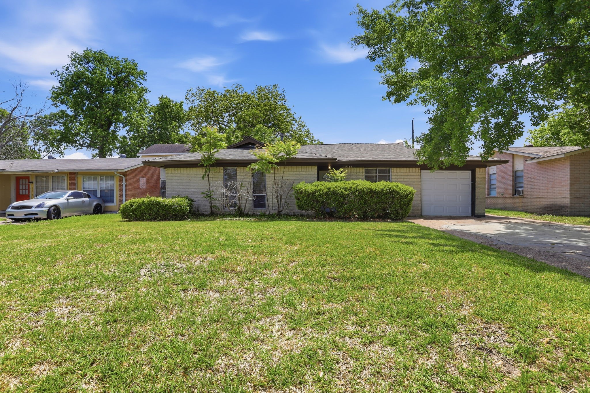 a front view of a house with a yard and trees