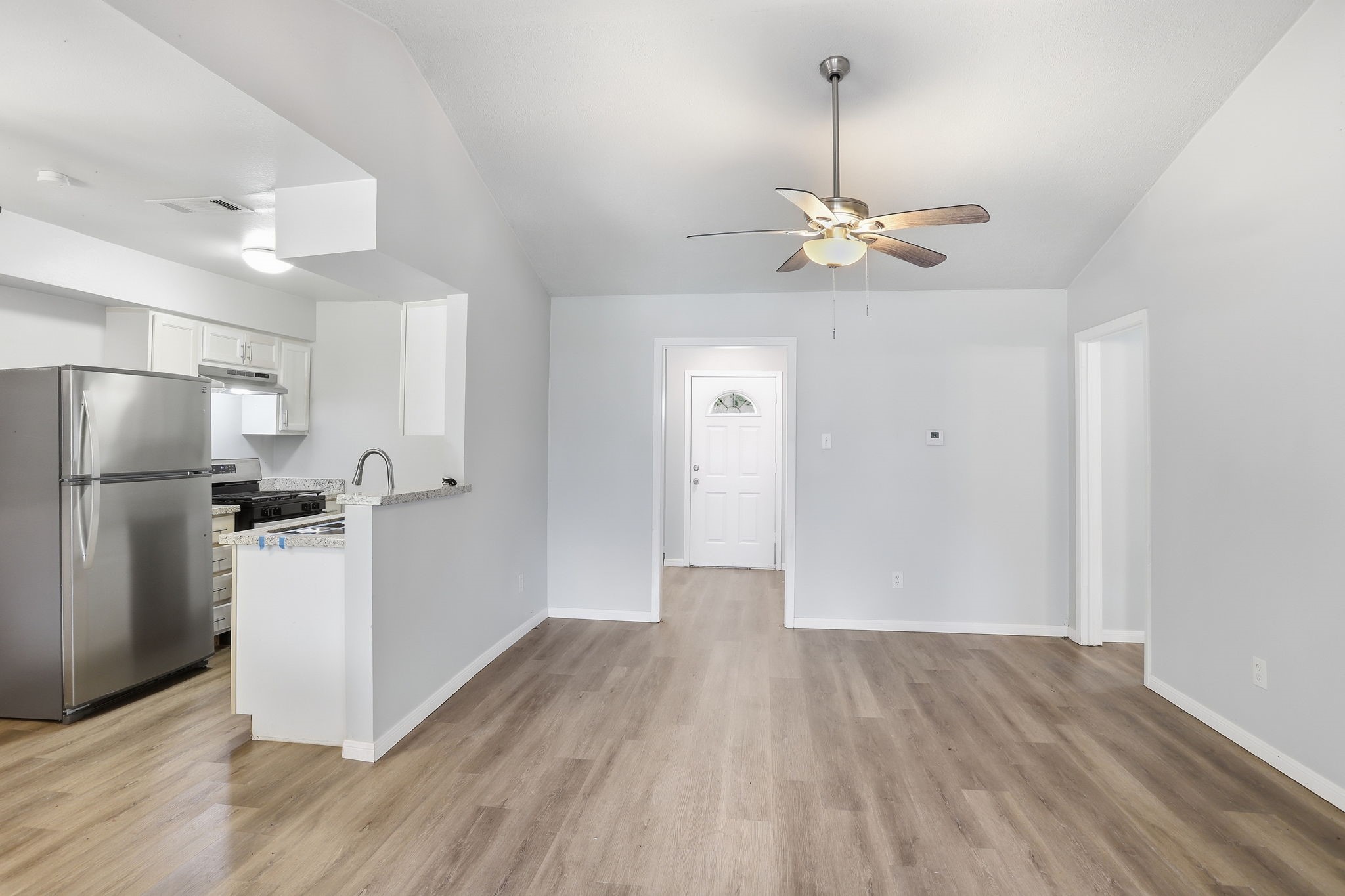 5242 Grace Point Lane Houston, TX 77048 - Photo 14 of 38 a view of a kitchen with wooden floor and a ceiling fan