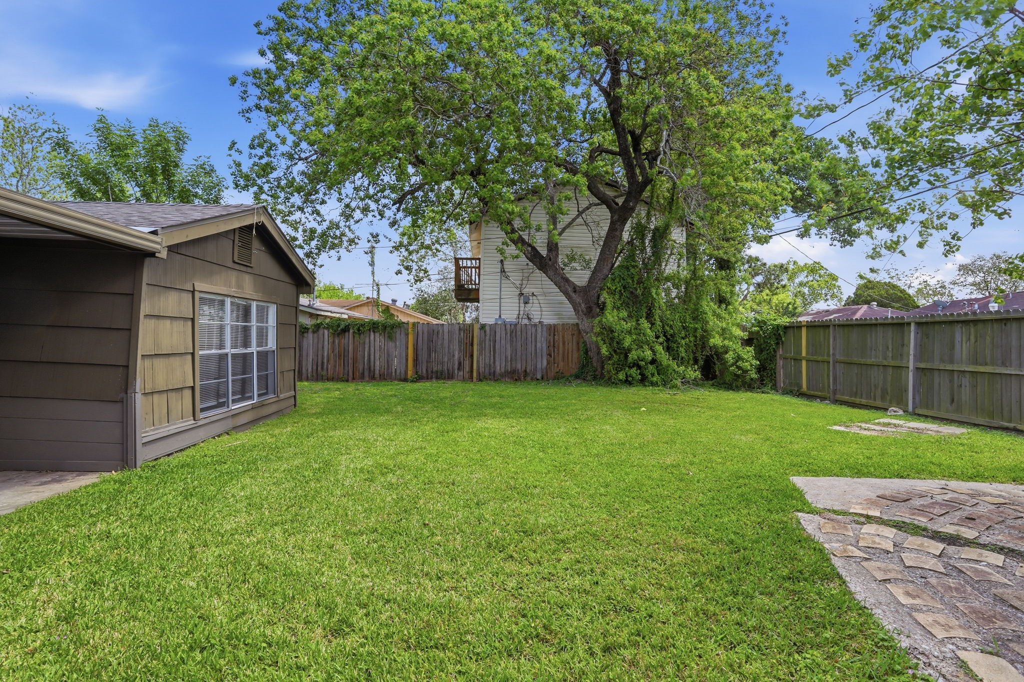 5242 Grace Point Lane Houston, TX 77048 - Photo 34 of 38 a view of a backyard with large trees and wooden fence