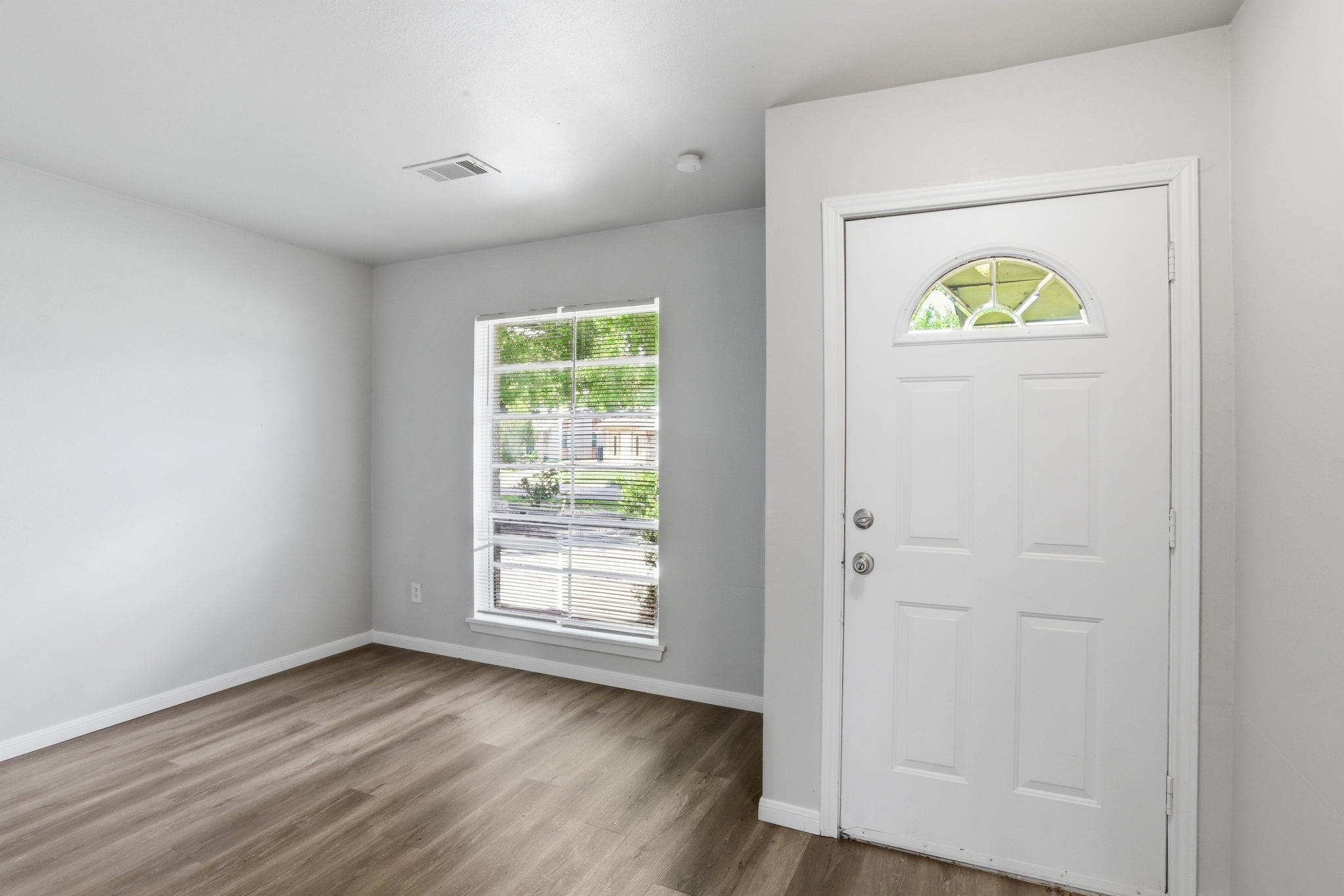 5242 Grace Point Lane Houston, TX 77048 - Photo 7 of 38 an empty room with windows and wooden floor
