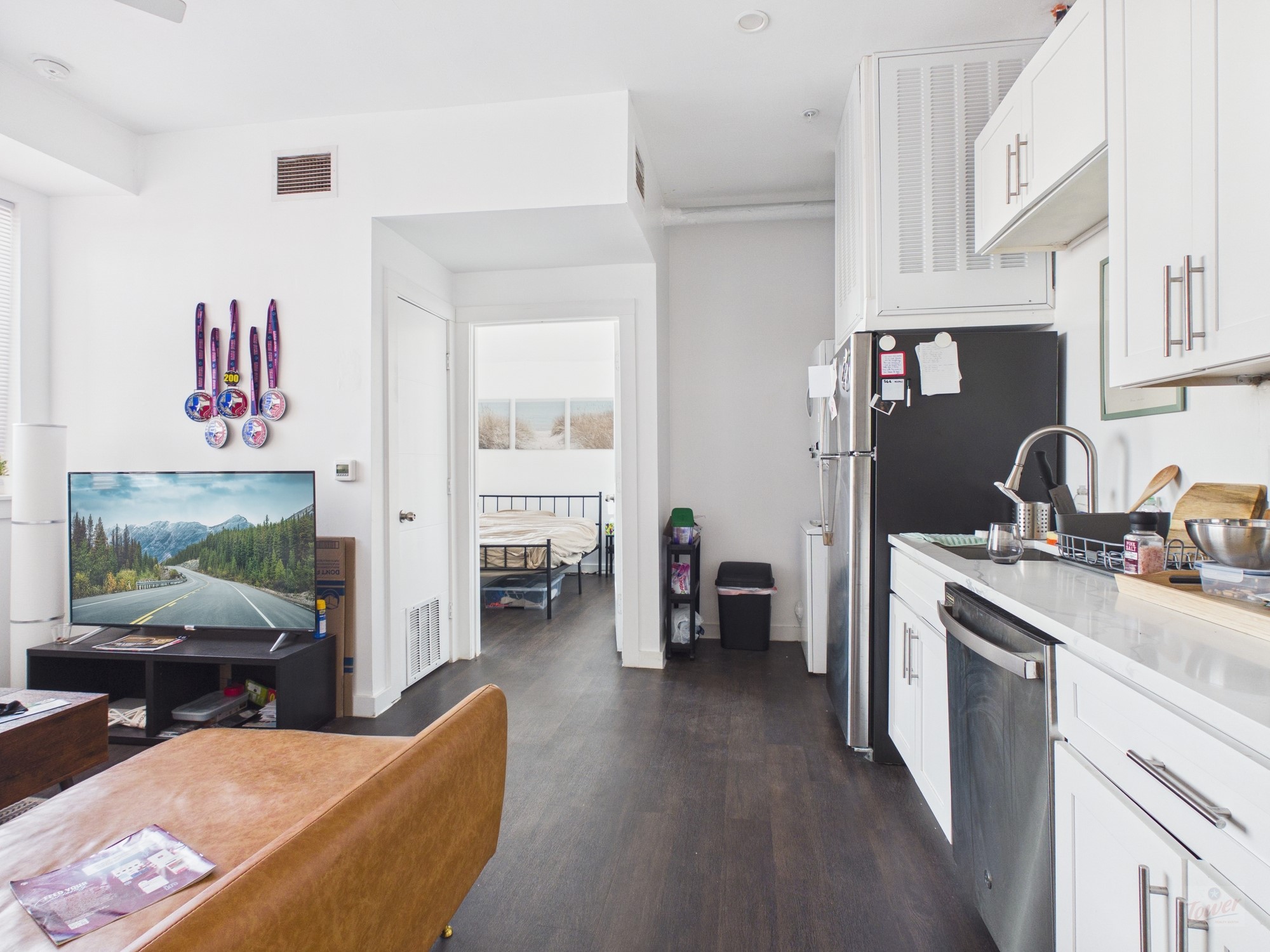 1010 West 26th Street, Unit 201 Austin, TX 78705 - Photo 2 of 8 a living room with furniture a flat screen tv and a fireplace
