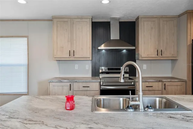 a kitchen with stainless steel appliances granite countertop a sink dishwasher and stove