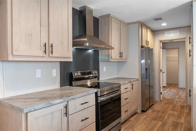 a kitchen with stainless steel appliances granite countertop a stove a sink and a refrigerator