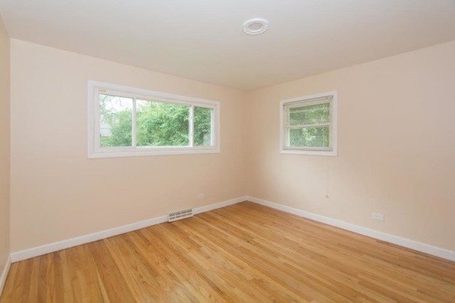 716 Ranch Road Wheaton, IL 60187 - Photo 12 of 24 an empty room with wooden floor and windows