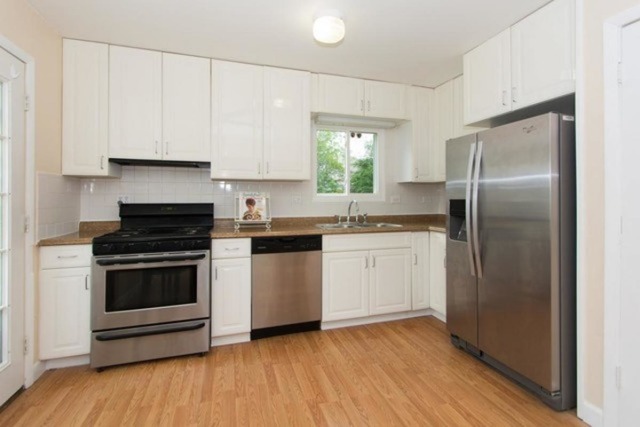 716 Ranch Road Wheaton, IL 60187 - Photo 8 of 24 a kitchen with a refrigerator stove and white cabinets