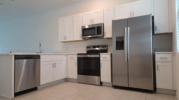 a kitchen with stainless steel appliances a refrigerator stove and microwave