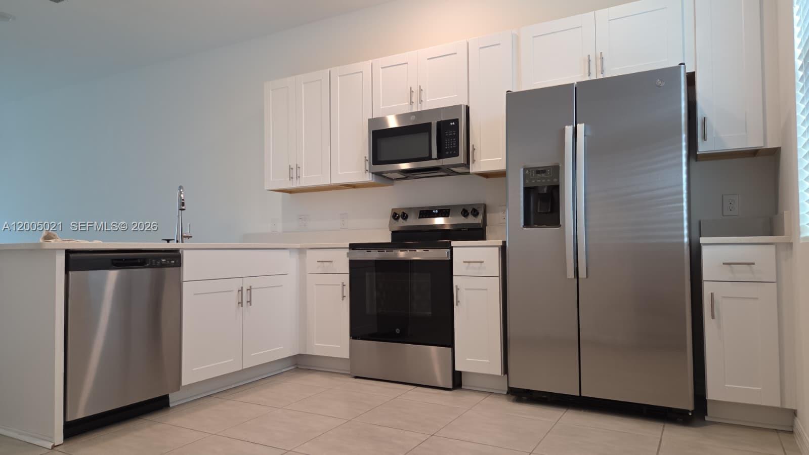 a kitchen with stainless steel appliances a refrigerator stove and microwave