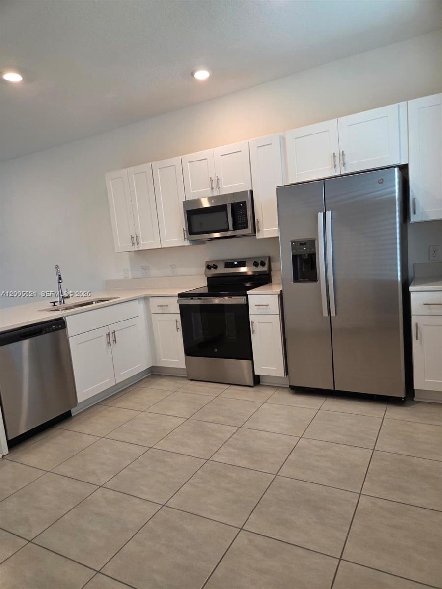 3230 Skyline Loop, Unit 3230 Kissimmee, FL 34758 - Photo 2 of 8 a kitchen with granite countertop a refrigerator and a sink