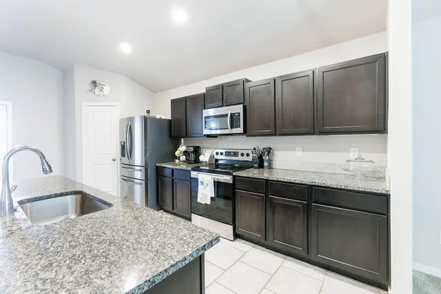 a kitchen with stainless steel appliances granite countertop a sink stove and refrigerator