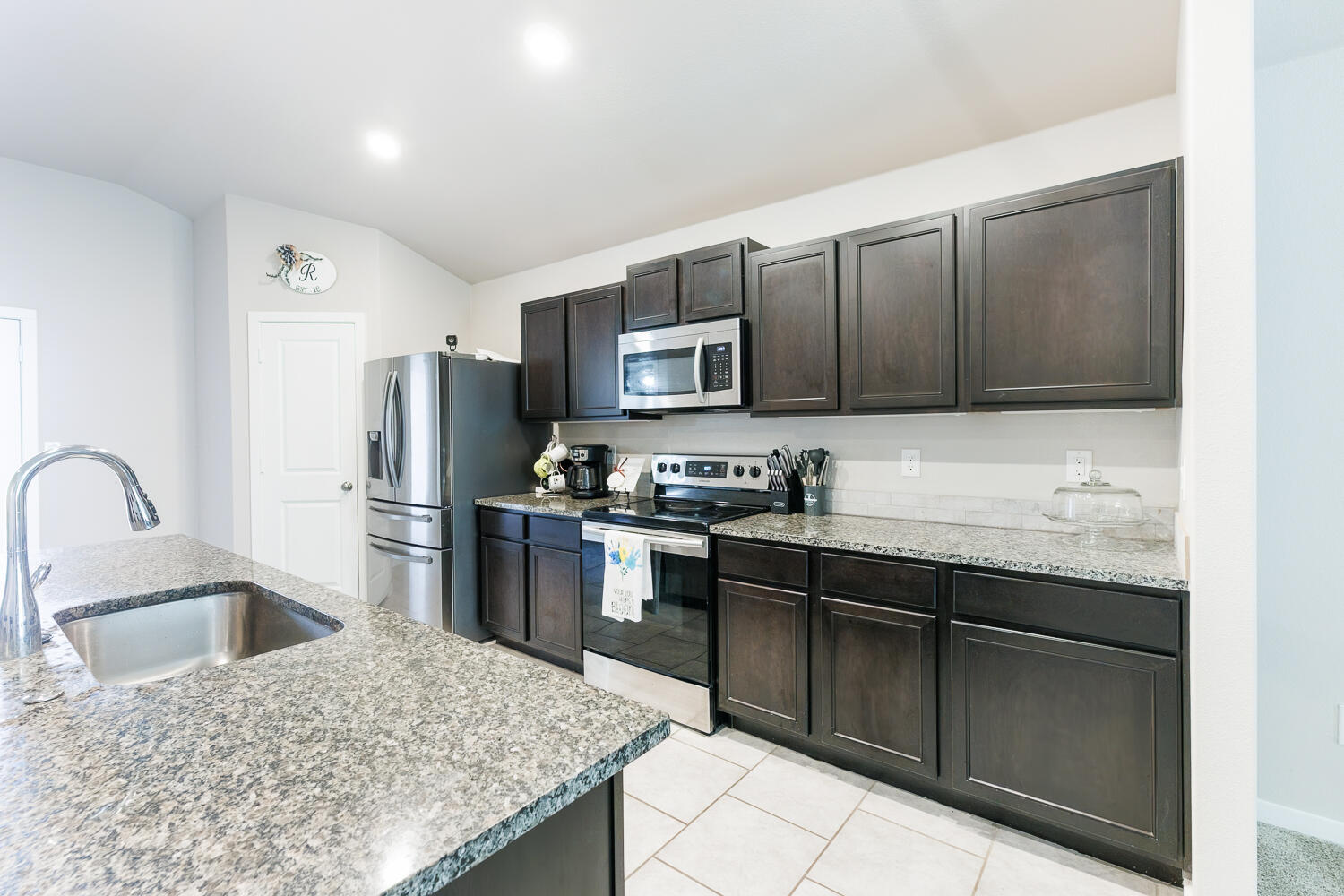 7322 29th Street Lubbock, TX 79407 - Photo 11 of 40 a kitchen with stainless steel appliances granite countertop a sink stove and refrigerator