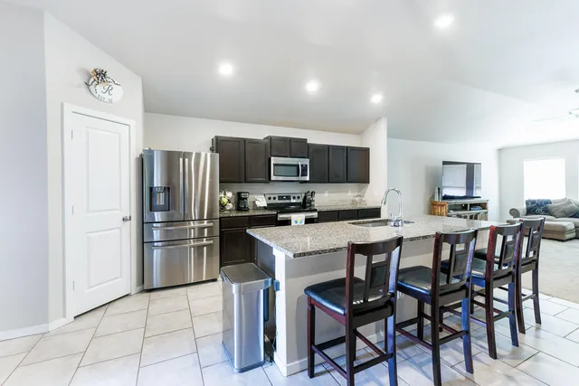 a kitchen with stainless steel appliances granite countertop a sink stove and cabinets