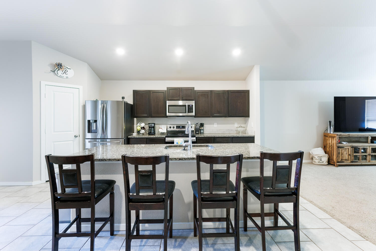 7322 29th Street Lubbock, TX 79407 - Photo 14 of 40 a kitchen with stainless steel appliances a dining table chairs microwave and sink