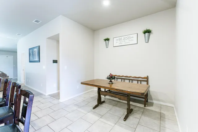 a kitchen with stainless steel appliances a dining table chairs microwave and sink