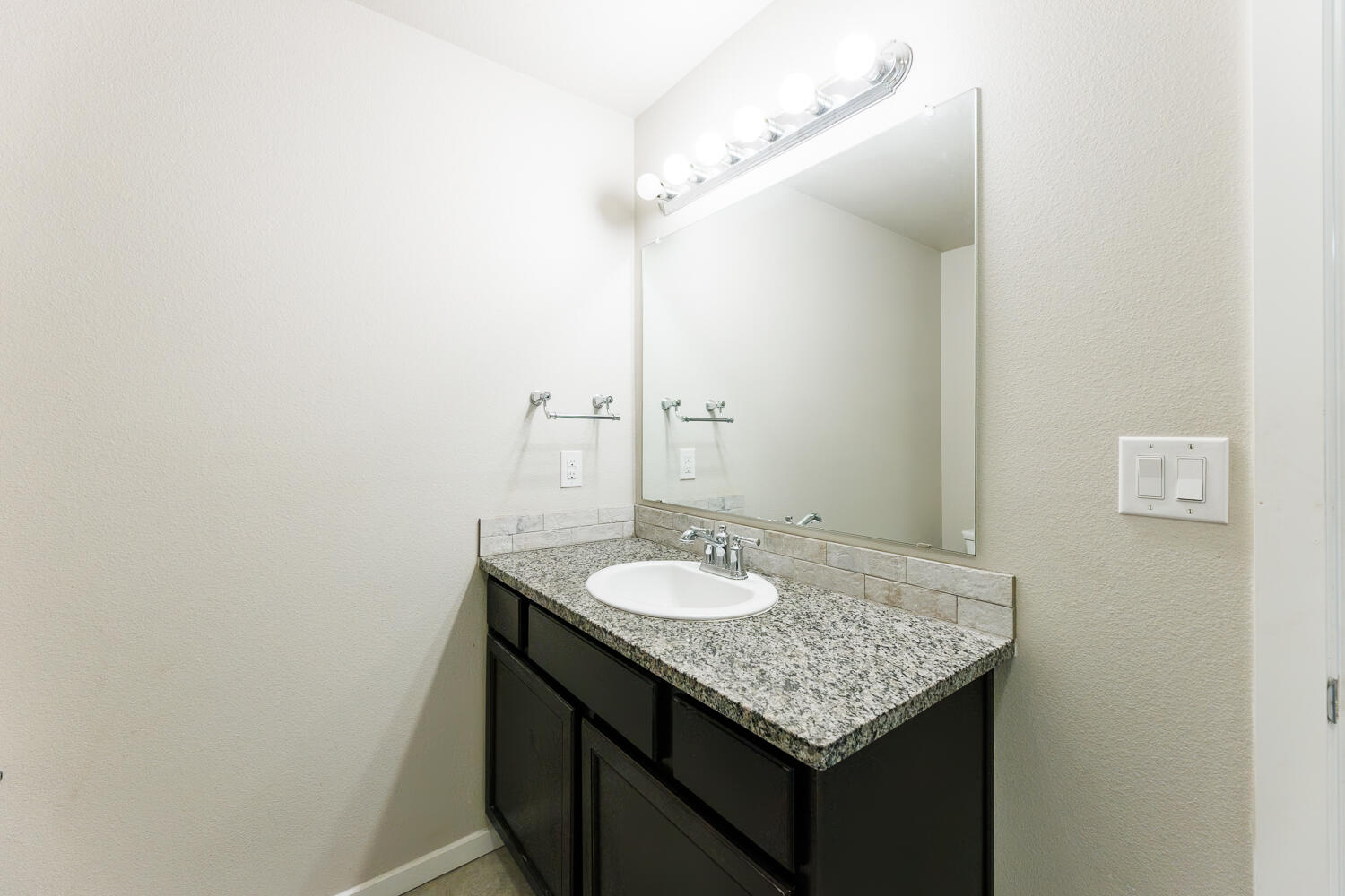 7322 29th Street Lubbock, TX 79407 - Photo 21 of 40 a bathroom with a granite countertop sink and a mirror