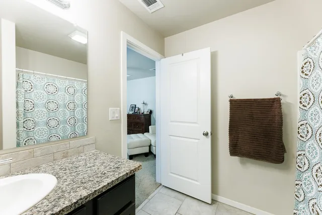 a bathroom with a granite countertop sink and a mirror