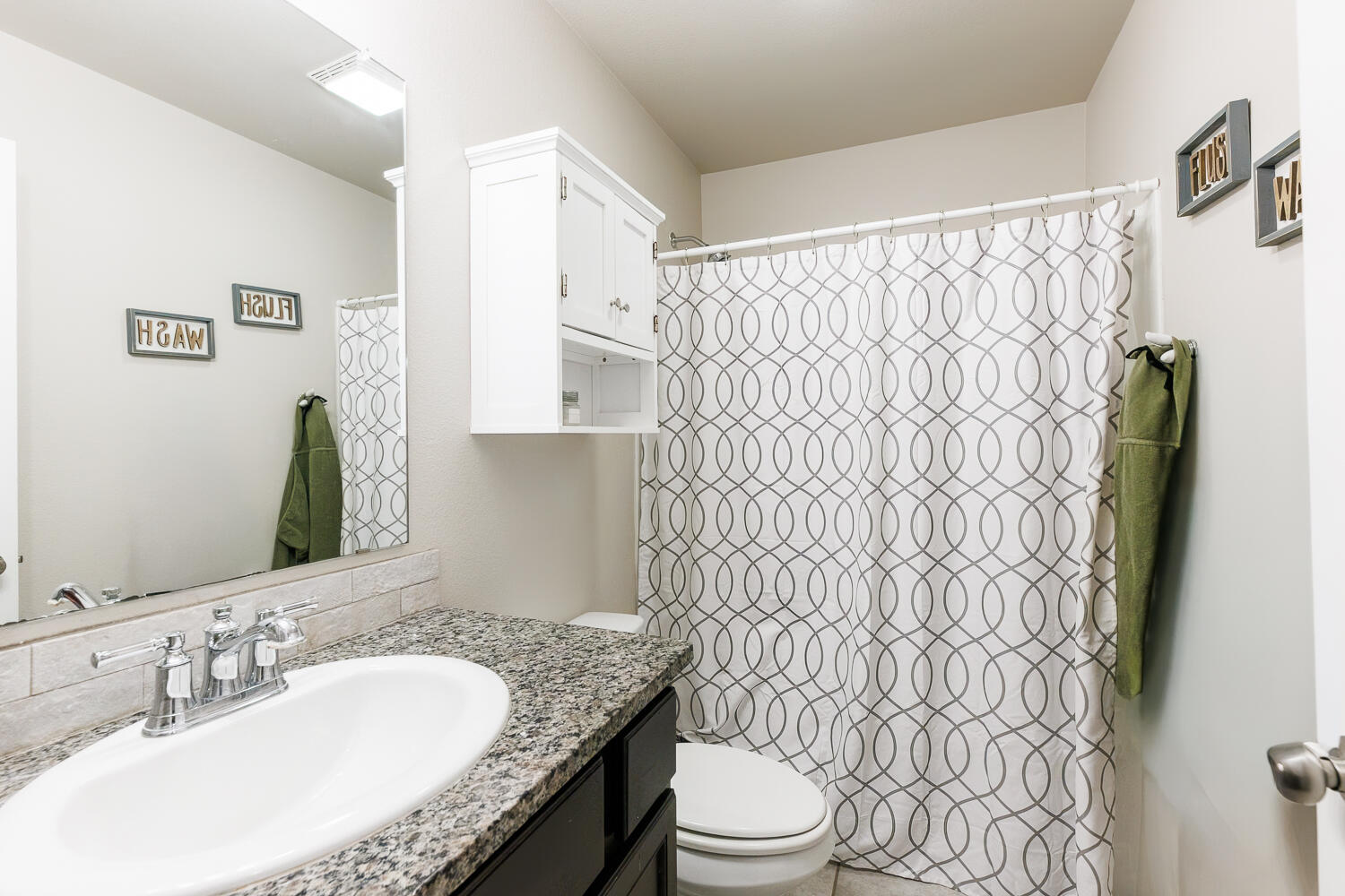 7322 29th Street Lubbock, TX 79407 - Photo 25 of 40 a bathroom with a granite countertop sink and a mirror