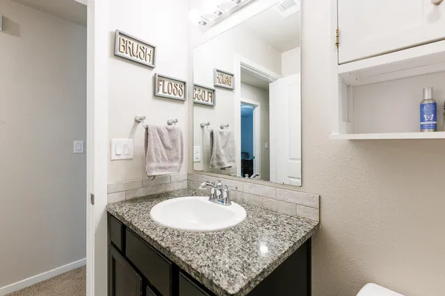 a bathroom with a granite countertop sink and a mirror