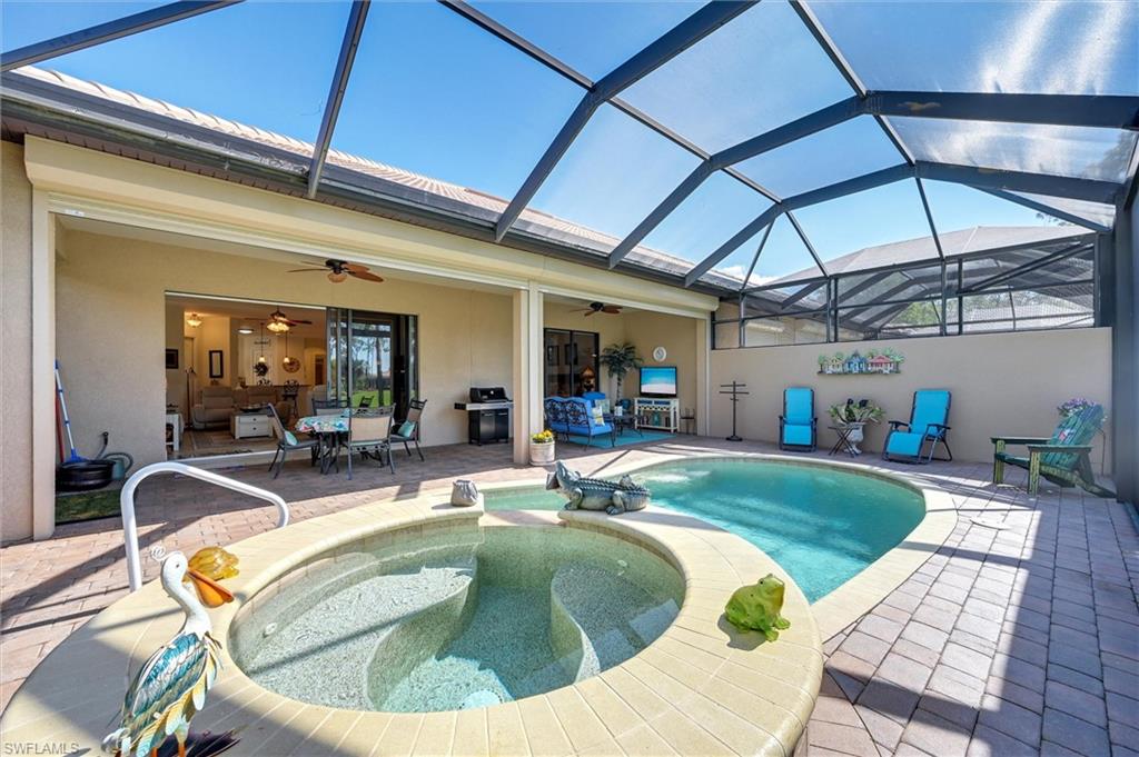 7587 Moorgate Point Way Naples, FL 34113 - Photo 13 of 50 Screened outdoor living area with a built-in spa and swimming pool, paver patio, and covered lanai with a ceiling fan