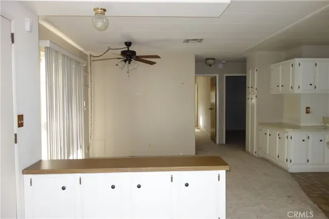 a kitchen with white cabinets and refrigerator