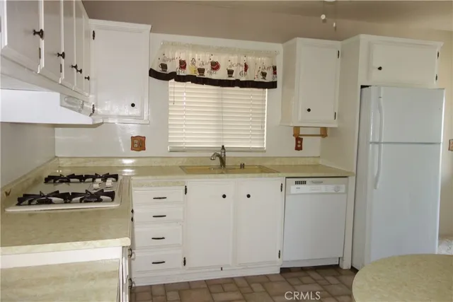 a kitchen with white cabinets and sink