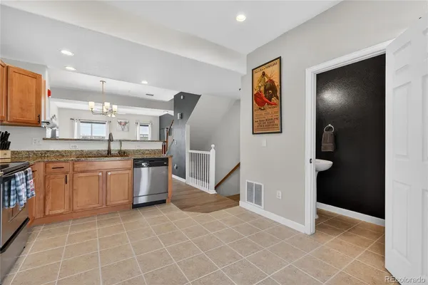 a kitchen with stainless steel appliances granite countertop a stove a sink and a microwave